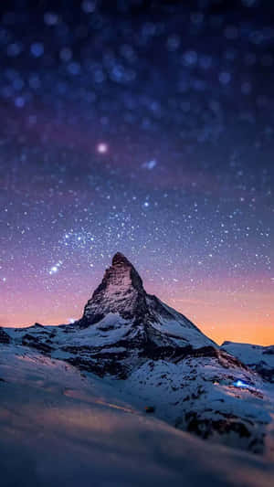 A Snowy Winter Scene Of Mountains And Trees In The Background, With An Iphone 6 Plus In The Foreground Wallpaper