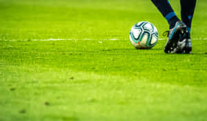 A Soccer Player Kicking A Ball Wallpaper