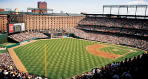 A Spectacular Panoramic View Of A Baseball Stadium During Sunset Wallpaper