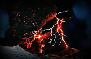 A Spectacular View Of Red Lightning Striking Through A Majestic Mountain Range. Wallpaper