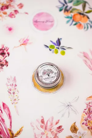 A Spring Perfume Bottle Amidst Blossoming Flowers Wallpaper