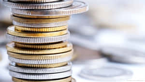 A Stack Of Gleaming Silver And Gold Coins Wallpaper