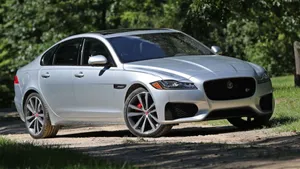 A Stately Black Jaguar Xf In A Mountain Vista Wallpaper