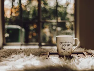 A Steaming Cup Of Brown Coffee On A Wooden Table Wallpaper