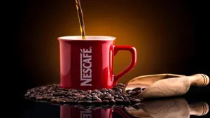 A Steaming Cup Of Brown Coffee, Served Amidst Aromatic Coffee Beans. Wallpaper