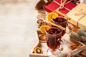 A Steaming Mug Of Mulled Wine With Cinnamon Sticks And Orange Slices Wallpaper