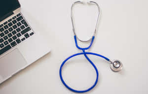 A Stethoscope Next To A Laptop And A Laptop Wallpaper