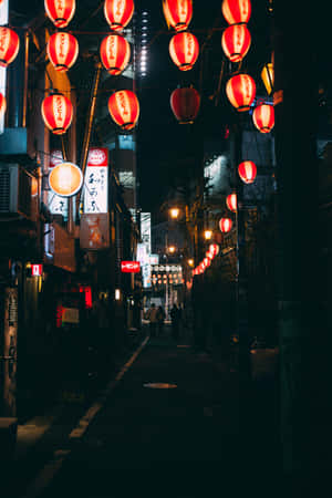 A Street With Many Lanterns Hanging From The Ceiling Wallpaper