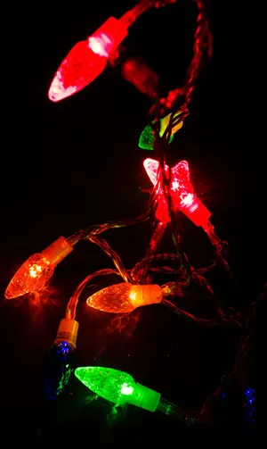 A String Of Multi Colored Christmas Lights Wallpaper