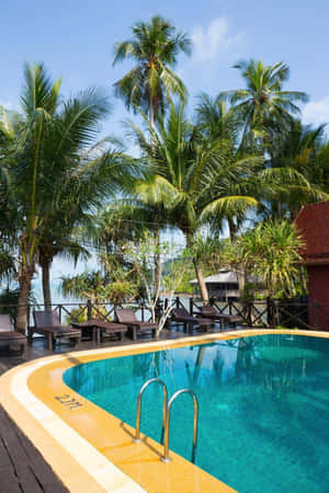 A Stunning Beach Swimming Pool Overlooking The Ocean At Sunset Wallpaper