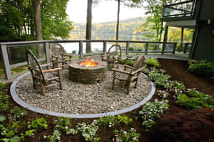 A Stunning Garden Design Featuring A Waterfall And Wooden Bridge Wallpaper