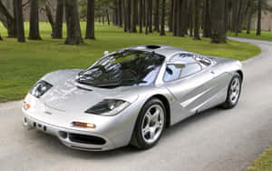 A Stunning Mclaren F1 Sports Car Showcased Against A Breathtaking Mountain Backdrop. Wallpaper