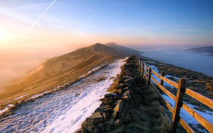 A Stunning Mountain Landscape With A Wooden Fence Wallpaper