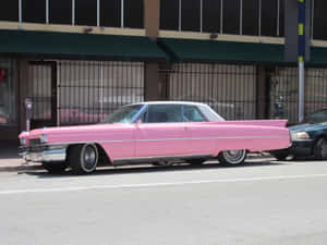 A Stunning Pink Cadillac Gleaming In The Sun Wallpaper