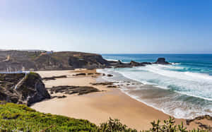 A Stunning View Of Portuguese Beach At Sunset Wallpaper