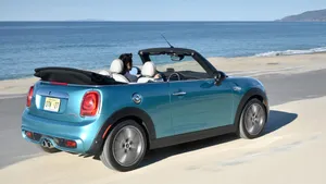 A Stylish Mini Cooper Convertible Parked By The Beachside. Wallpaper