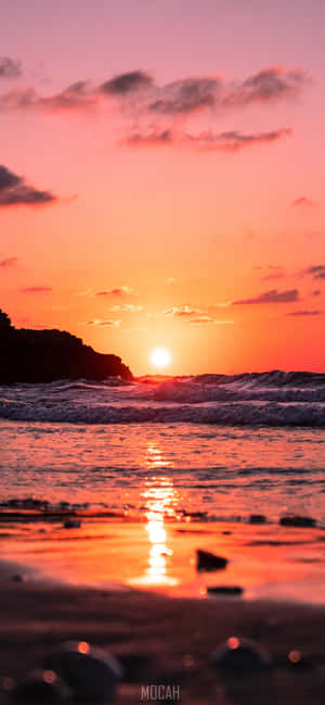 A Sun-kissed Sunrise On A Beach, Perfect For A Scenic Iphone Wallpaper Wallpaper