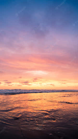 A Sunset On The Beach With A Colorful Sky Wallpaper