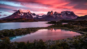 A Sunset Over A Lake And Mountains Wallpaper