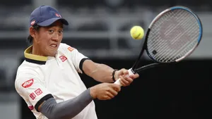 A Tennis Player Swinging His Racket At A Ball Wallpaper