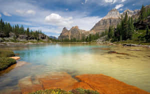 A Tranquil And Serene View Of A Blue-green Lake Wallpaper