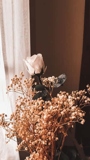 A Vase Of Dried Flowers On A Table Wallpaper