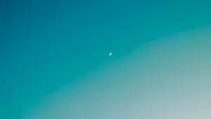A Vibrant And Beautiful Ombre Sky Featuring A Crescent Moon Wallpaper