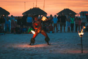 A Vibrant Beach Party Under The Sunset Sky Wallpaper