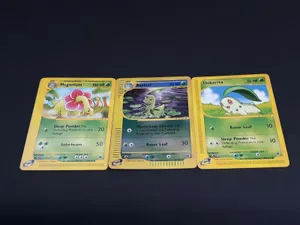 A Vibrant Depiction Of Meganium, Bayleef, And Chikorita In Pokémon Trading Cards Wallpaper