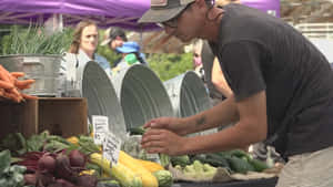 A Vibrant Farmers Market With Colorful Stalls Of Fresh Produce Wallpaper