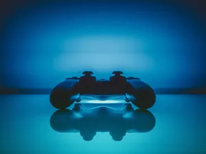 A Video Game Controller Is Sitting On A Blue Surface Wallpaper
