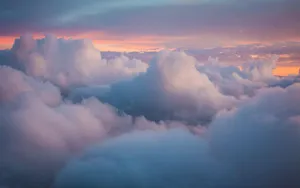 A View Of Clouds From An Airplane At Sunset Wallpaper