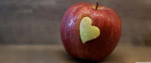 A View Of The Crisp And Colorful Apple Logo, Set Against A Powerful Background Wallpaper