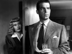 A Vintage Detective Standing In A Dimly Lit Room Wallpaper