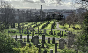 A Weathered Gravestone In A Serene Cemetery Wallpaper