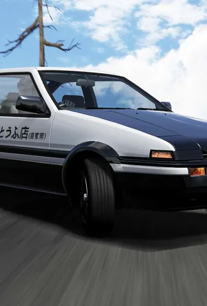 A White And Black Car Driving Down A Road Wallpaper