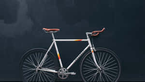 A White Bike Leaning Against A Dark Wall Wallpaper