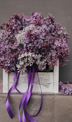 A White Crate With Purple Flowers And A Ribbon Wallpaper