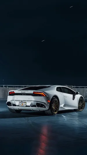A White Sports Car Is Parked In A Parking Lot Wallpaper