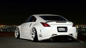 A White Sports Car Parked In Front Of A City Wallpaper