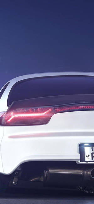 A White Sports Car With A Red Tail Light Wallpaper