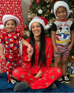 A Woman And Two Children In Christmas Pajamas Wallpaper