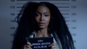 A Woman Holding A Mugshot In Front Of A Mugshot Wallpaper