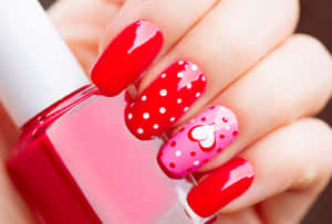 A Woman Holding A Red Nail Polish With Polka Dots Wallpaper