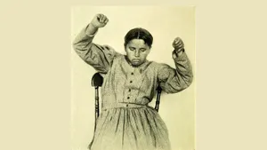 A Woman In A Dress Is Sitting In A Chair Wallpaper