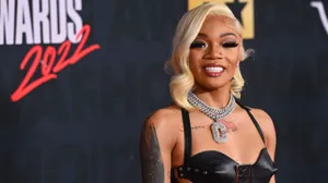 A Woman In A Leather Dress And A Black Bra Wallpaper