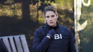 A Woman In A Police Uniform Is Standing Next To A Fence Wallpaper