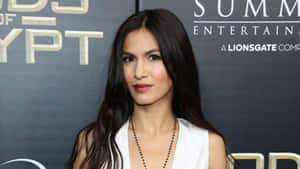 A Woman In A White Dress Is Posing On The Red Carpet Wallpaper