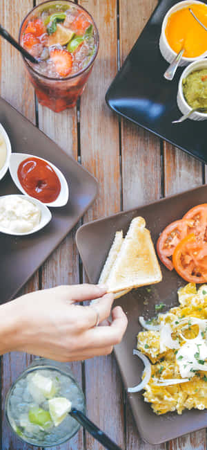 A Woman Is Grabbing A Plate Of Food Wallpaper