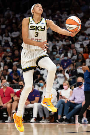 A Woman Is In The Air While Dribbling A Basketball Wallpaper